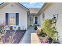 A welcoming front entrance showcasing a well-maintained walkway and landscaped garden beds on a sunny day at 7426 Painted Bunting Way, Hanahan, SC 29410