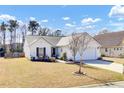 Inviting single-Gathering home with a tidy lawn, blue sky, two-car garage, and manicured landscaping at 7426 Painted Bunting Way, Hanahan, SC 29410