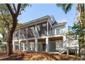 Rear view of home featuring spacious screened porch and elevated foundation with natural surroundings at 806 Jungle Rd, Edisto Island, SC 29438