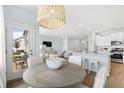 Inviting dining area with a round wooden table and stylish pendant lighting, flowing into the living space at 1020 Swamp Rose Run, Summerville, SC 29485