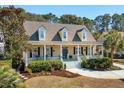 Inviting yellow home with dormer windows, covered porch, and professionally landscaped front yard at 1425 Lagoon Park Cir, Mount Pleasant, SC 29466