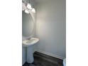 Stylish powder room features pedestal sink, modern lighting, and attractive wood-look floors at 2204 Scarlett Maple St, Summerville, SC 29486