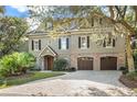 Charming home with a two-car garage, brick accents, and mature landscaping at 176 Marsh Hawk Ln, Kiawah Island, SC 29455