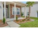 Inviting front porch featuring stone accents, a palm tree, and flower beds at 222 Medford Dr, Summerville, SC 29485