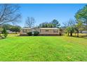 Charming single-story home with well-kept lawn, trees and a welcoming entrance on a sunny day at 2285 Cooper Store Rd, Moncks Corner, SC 29461
