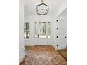 Bright foyer with brick floors, modern light fixture, and white trim throughout at 2725 Starfish Dr, Johns Island, SC 29455