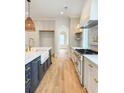 Bright kitchen featuring high-end appliances, a marble island with a farmhouse sink, and hardwood floors at 3902 Summerton St, Mount Pleasant, SC 29466