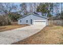 Charming blue home featuring an attached garage and driveway, surrounded by mature trees and an unfenced lawn at 4618 Moss Ct, Charleston, SC 29420