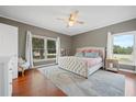 Bright main bedroom with large windows, hardwood floors, a plush bed, and neutral decor for a serene retreat at 4801 Coon Club Rd, Meggett, SC 29449