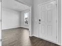 Bright foyer showcasing hardwood flooring, a white front door, and an open doorway leading to the living area at 511 Verdi Dr, Summerville, SC 29486