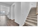 Inviting hallway featuring hardwood flooring, a staircase with carpeted steps, and an open view to the living spaces at 511 Verdi Dr, Summerville, SC 29486
