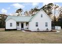 Inviting home with a metal roof, covered porch, and manicured landscaping at 5529 Golden Rice Ln, Ravenel, SC 29470