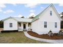 A beautifully landscaped front yard leads to this inviting home featuring a metal roof at 5529 Golden Rice Ln, Ravenel, SC 29470