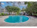 Community pool with lounge chairs surrounded by mature trees and landscaping at 60 Fenwick Hall Allee # 728, Johns Island, SC 29455