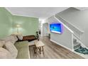 Cozy living room featuring a mounted TV, stairs to the next level, and stylish sofa at 6244 Lucille Dr # B, North Charleston, SC 29406