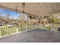Covered porch features gray tiled floors and white railing overlooking lush backyard at 7461 Church Hill Rd, Hollywood, SC 29449