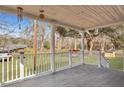Covered porch features gray tiled floors and white railing overlooking lush backyard at 7461 Church Hill Rd, Hollywood, SC 29449