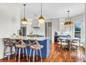 Stylish kitchen with a breakfast bar, marble countertops, modern pendant lights, and hardwood floors at 904 Watermelon Run, Charleston, SC 29412