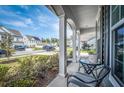Cozy front porch view with patio seating, flowers, and neighborhood street at 9981 Winged Elm St, Ladson, SC 29456