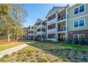 Scenic view of condo building with mature trees, manicured lawns, and inviting screened porches for relaxing outdoors at 1025 Riverland Woods Pl # 801, Charleston, SC 29412