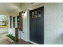 Close-up of the front entry featuring a black door, white painted brick, and dark-stained porch at 1114 Margaret Dr, Ladson, SC 29456