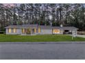 Charming single-story house with a brick exterior, with large trees in background, viewed from the street at 123 Sharon Dr, Walterboro, SC 29488