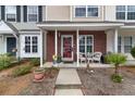 Charming townhome featuring a brick facade, covered front porch, and a cozy seating area at 138 Taylor Cir, Goose Creek, SC 29445