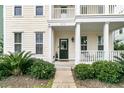 Inviting front porch with classic white railing and a cozy seating area at 1878 Carolina Bay Dr, Charleston, SC 29414