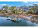 Aerial shot of a neighborhood on the water, featuring a long wooden dock and serene water views at 2040 Ashburton Way, Mount Pleasant, SC 29466