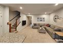 Cozy living room with a sectional sofa, mounted TV, staircase, and view into the entryway at 205 Grand Palm Ln, Summerville, SC 29485