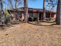 Exterior view of a brick home with a covered porch and mature trees in a natural setting at 205 Longstreet St, Summerville, SC 29486