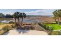 Expansive marsh view from backyard, complete with mature landscaping and palm trees at 23 Lowndes Pointe Dr, Charleston, SC 29403