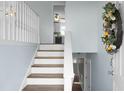 Bright entryway featuring wood and white stairs, with views of the kitchen and multiple doorways at 2901 Newport Pl, North Charleston, SC 29420
