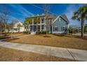 Inviting two-story home with a charming front porch and well-manicured lawn in a Gathering-friendly neighborhood at 2975 Yachtsman Dr, Mount Pleasant, SC 29466