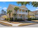 Charming two-story home featuring a double porch, landscaped yard, and palm trees at 301 Forsythia Ave, Summerville, SC 29483