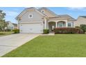 Charming single-Gathering home with a well-manicured lawn, mature tree, and covered front porch at 303 Sand Dune Trl, Summerville, SC 29486