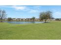 Scenic view of the pond and surrounding community homes, complemented by green lawn at 303 Sand Dune Trl, Summerville, SC 29486