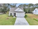 Inviting home exterior with a neatly maintained lawn, a two-car garage, and an attractive front garden at 3109 Hugh Bennett Dr, Johns Island, SC 29455