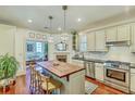 Bright kitchen features center island with wood countertop, stainless steel appliances, and hardwood floors at 312 President St, Charleston, SC 29403