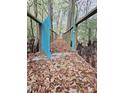 Enchanting wooden bridge with a charming blue gate surrounded by woodland vegetation, creating a magical entry through nature at 3695 Cannon Rd, Round O, SC 29474