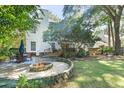 Inviting backyard with a stone patio, fire pit, outdoor dining area, and lush landscaping at 405 Springfield Rd, Mount Pleasant, SC 29464