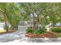 Classic two-story white home with a double porch and black shutters nestled among mature trees at 405 Springfield Rd, Mount Pleasant, SC 29464