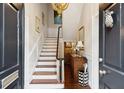 Elegant foyer featuring a staircase, chandelier, and stylish décor, creating a welcoming ambiance at 41 Tradd St, Charleston, SC 29401