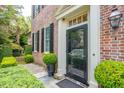 Inviting front entrance with a black door, brick facade, and meticulously manicured greenery at 41 Tradd St, Charleston, SC 29401