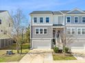 Charming two-story townhome with gray siding, white trim, one-car garage, and manicured lawn at 591 Mclernon Trace, Johns Island, SC 29455
