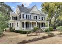 Elegant home boasting a grand front porch, complemented by a lush landscaped yard and a classic architectural design at 710 S Main St, Summerville, SC 29483