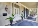 Charming front porch showcasing elegant doors, lighting fixtures, potted plants, and porch swing at 710 S Main St, Summerville, SC 29483
