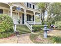 Inviting front porch with decorative fountain and lush plants leading to the home's entrance at 710 S Main St, Summerville, SC 29483