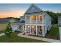 Charming two-story home with light blue siding, a covered porch and manicured lawn at 742 Maynard Ln, Summerville, SC 29486