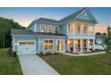 Charming two-story home with light blue siding, a covered porch and an attached garage at 742 Maynard Ln, Summerville, SC 29486